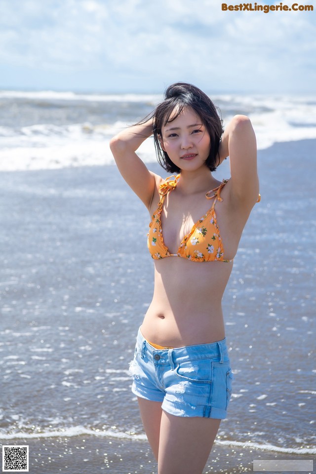 A woman in a bikini standing on the beach.
