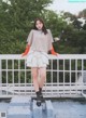 A woman standing on top of a white railing.