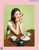 A woman sitting at a table with a plate of food.